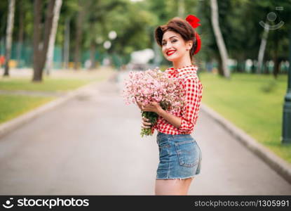 Pinup girl with bouquet of flowers, retro american fashion. Cute smiling woman in pin up style. Pinup girl with bouquet of flowers, retro fashion