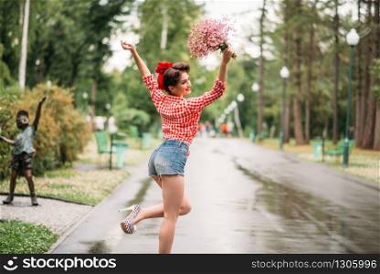 Pinup girl with bouquet of flowers, retro american fashion. Cute smiling woman in pin up style. Pinup girl with bouquet of flowers, retro fashion