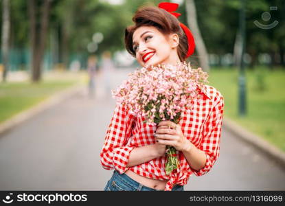 Pinup girl with bouquet of flowers, retro american fashion. Cute smiling woman in pin up style