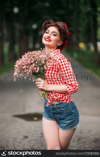 Pinup girl with bouquet of flowers, retro american fashion. Cute smiling woman in pin up style. Pinup girl with bouquet of flowers, retro fashion