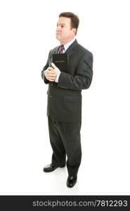 Pious minister or businessman holding his bible and looking thoughful. Full body isolated on white.