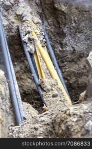 Pipe and cables in the soil after digging. The building of lines of cables construction of communication network connection.