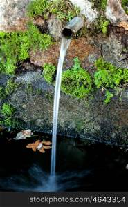 Pipe clean water pouring from a natural source