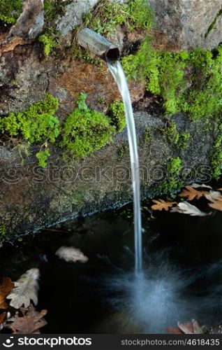 Pipe clean water pouring from a natural source&#xA;
