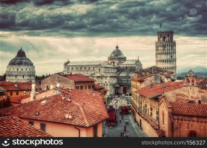 Pisa Cathedral with the Leaning Tower panorama. Unique vintage perspestive from rooftop, dark clouds. Tuscany, Italy. Pisa Cathedral with the Leaning Tower panorama. Unique rooftop view.