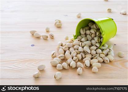 Pistachio nuts are lined on the wooden floor.