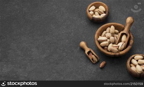 pistachio nuts bowls with wooden spoons copy space