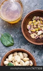 Pistachio nuts,healthy snacks.Salted pistachios for beer.Pistachio nuts in the bowl. Pistachios nuts on wooden table