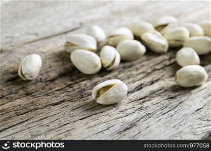 Pistachio nuts on wood background