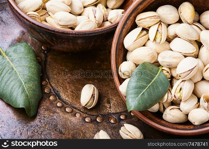 Pistachio with leaf.Dish full of pistachios.Nut.Pistachio in nutshell. Pistachio with leaf