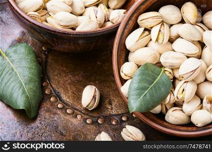 Pistachio with leaf.Dish full of pistachios.Nut.Pistachio in nutshell. Pistachio with leaf