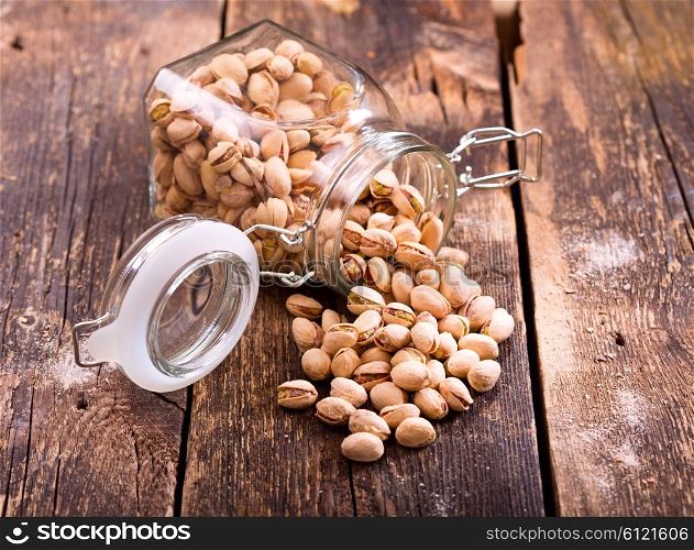 pistachios in a glass jar on wooden table