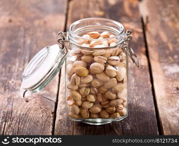 pistachios in a glass jar on wooden table