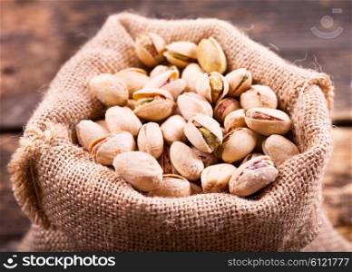 pistachios in a sack on wooden background