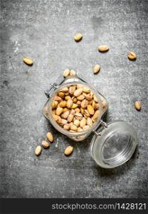 Pistachios in the jar. On the stone table.. Pistachios in the jar.