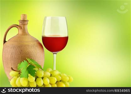 Pitcher with grape wine, glass and bunch grapes on blurred green background