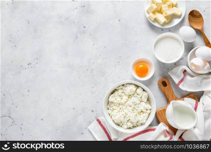 Pitcher with milk, egg, cottage cheese, butter and yogurt on kitchen table. Ingredients for cooking on kitchen table. Culinary background. Top view. Flat lay