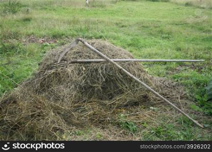 pitchfork and scythe on a pile of hay