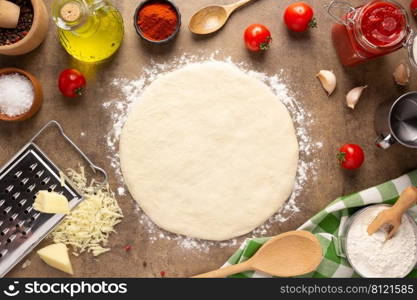 Pizza and dough homemade cooking with ingredients at table. Pizza with sauce on tabletop background. Recipe concept in kitchen