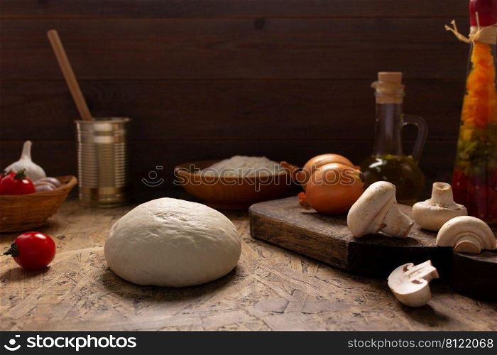 Pizza and dough homemade cooking with ingredients at table. Pizza with sauce on tabletop background. Recipe concept in kitchen