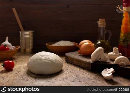 Pizza and dough homemade cooking with ingredients at table. Pizza with sauce on tabletop background. Recipe concept in kitchen