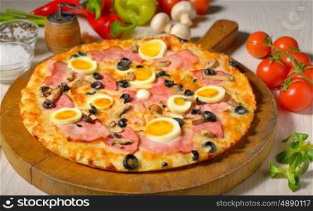 Pizza and ingredients on old wooden board