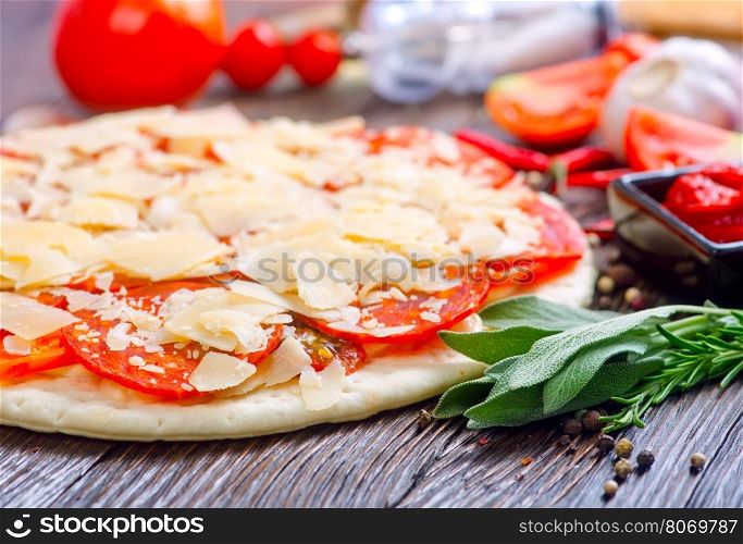 pizza and ingredients on the wooden table