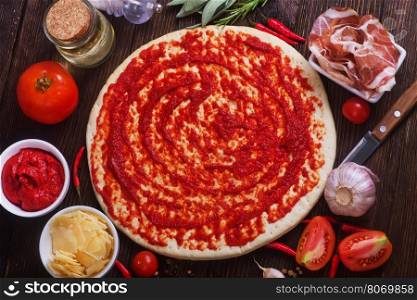 pizza and ingredients on the wooden table
