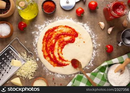 Pizza and sauce homemade cooking or baking on table. Dough pizza at tabletop background top view. Recipe concept in kitchen