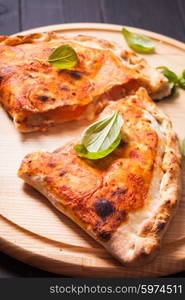 Pizza calzone with basil leaves close up. The Pizza calzone