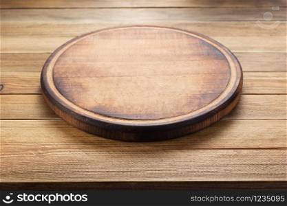 pizza cutting board at rustic wooden table plank background, front view