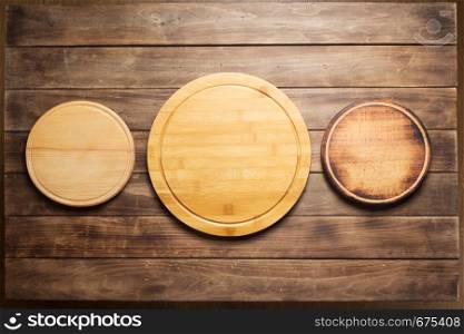 pizza cutting board at wooden plank table board background, top view