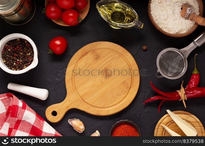 Pizza cutting board with ingredients at table. Wheat flour for pizza on tabletop background. Recipe concept in kitchen