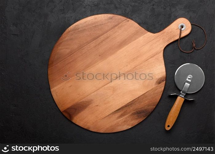 Pizza cutting board with pizza knife on dark rustic background