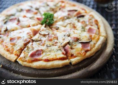 Pizza ham and mushroom on wood