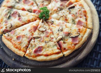 Pizza ham and mushroom on wood in sepia