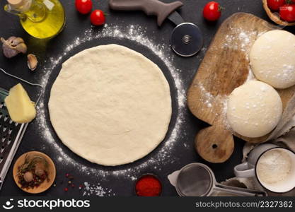Pizza homemade cooking or baking on table. Dough pizza at slate tabletop background. Recipe concept in kitchen