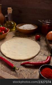 Pizza homemade cooking or baking on table. Dough pizza at wooden tabletop background. Recipe concept in kitchen