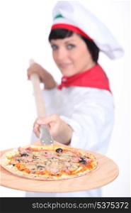 Pizza maker displaying her pizza