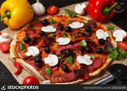 Pizza on cooking paper with ingredients