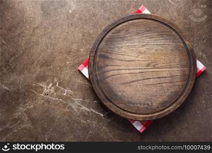 Pizza or bread cutting board and cloth napkin for homemade baking on table. Food recipe concept at stone background texture with copy space. Flat lay top view