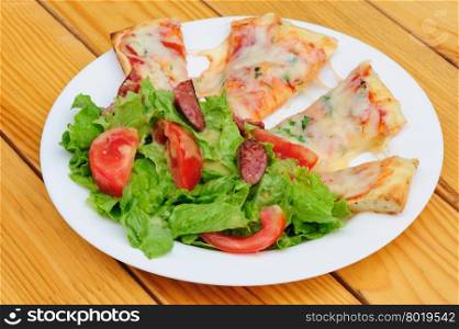 Pizza slices with melted cheese and fresh vegetables salad. Pizza slices and salad