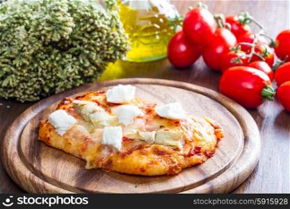 pizza with artichoke and oregan on wood