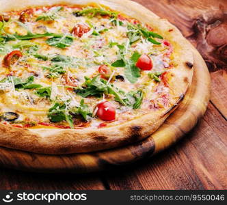 Pizza with arugula, cheese, yoghurt and cherry tomatoes closeup