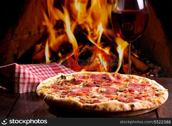 pizza with bacon, salami and glass of wine