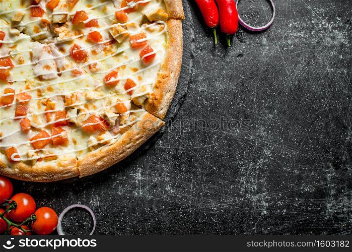 Pizza with chicken and cheese sauce. On dark rustic background. Pizza with chicken and cheese sauce.