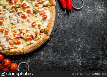 Pizza with chicken and cheese sauce. On dark rustic background. Pizza with chicken and cheese sauce.