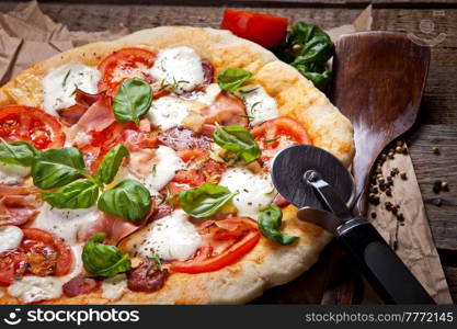 Pizza with dry cured ham and basil