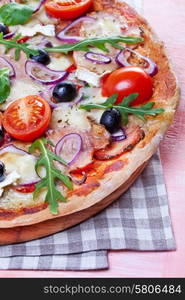 Pizza with dry cured ham and salad