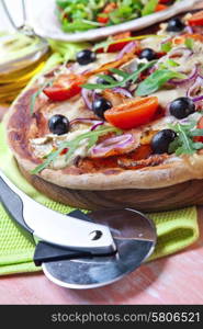 Pizza with dry cured ham and salad